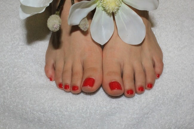 Füße mit roten Fußnägeln nach Fußpflege-Termin